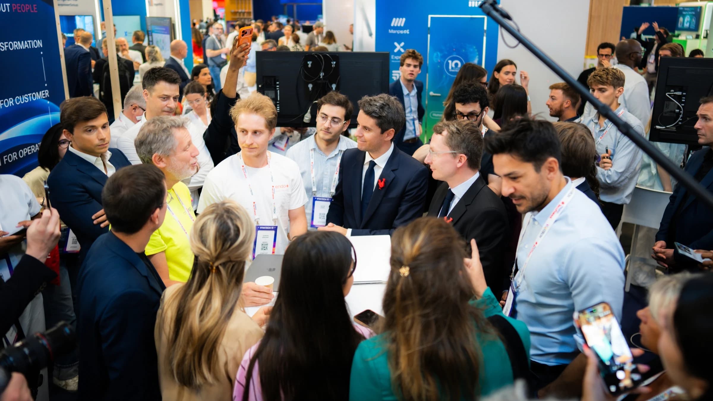 Gabriel Attal s'exprime debout, un micro à la main, au salon VivaTech devant un écran géant.