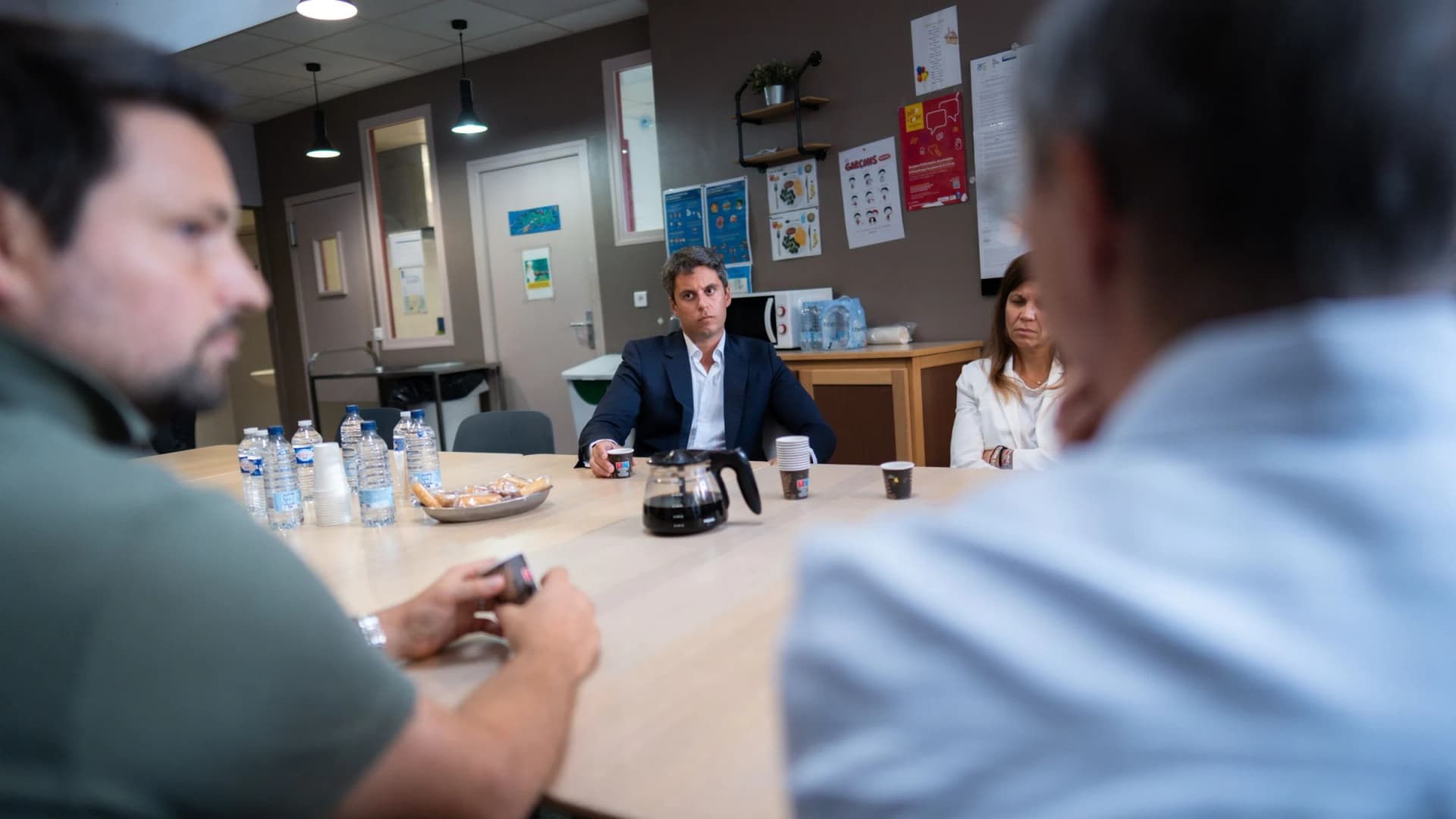 Gabriel Attal autour d'une table ronde en train d'écouter un monsieur 