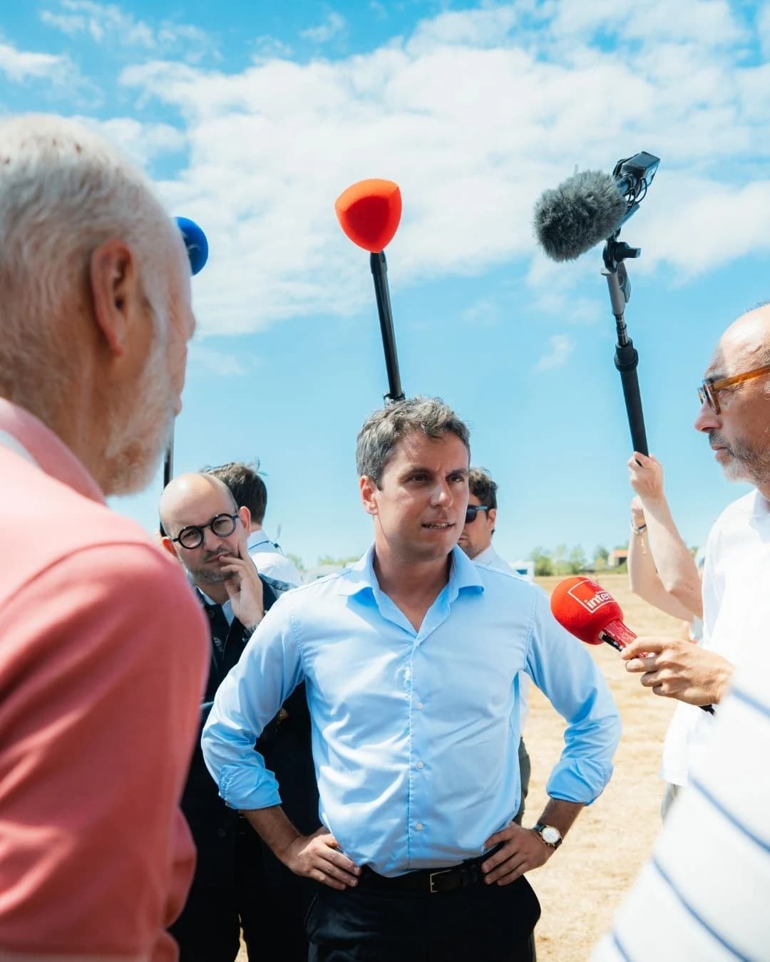 Gabriel Attal en train d'écouter deux qui parlent 